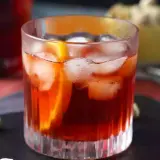 Ett glas Negroni med is och apelsinskiva, perfekt för att följa ett negroni recept.