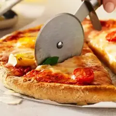 En pizza med tomater och basilika skärs upp. Ett perfekt glutenfri pizzadeg recept för alla.