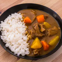 En tallrik med ångande ris och en mustig japansk curry med mört kött, potatis och morötter.