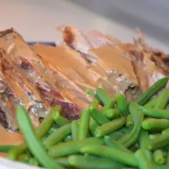 Skinkstek i gryta, saftig och uppskuren, serveras med en krämig sås och gröna bönor. En klassisk och smakrik rätt.