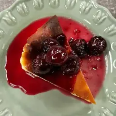 En bit krämig ostkaka med körsbärssås, perfekt för ett ostkaka recept.