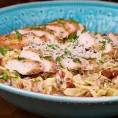 En härlig kyckling pasta med krämig sås, bacon och parmesanost, toppad med färsk persilja.