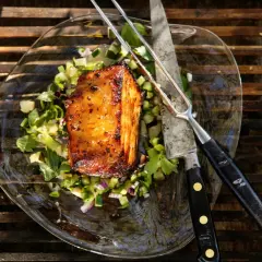 En saftig köttbit med grönsallad, kniv och gaffel. Perfekt för ett libbsticka recept.