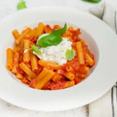 En krämig pasta med tomatsås och en generös klick burrata, perfekt för ett enkelt burrata recept. Garnerad med färsk basilika.