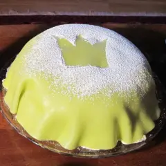 En ljusgrön prinsesstårta med ett kronmönster av pudersocker. Kanske heter den så för att den är så kungligt god?