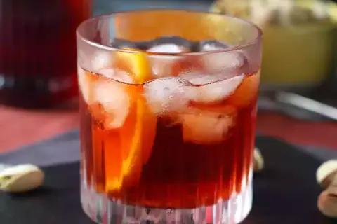 Ett glas Negroni med is och apelsinskiva, perfekt för att följa ett negroni recept.