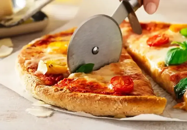 En pizza med tomater och basilika skärs upp. Ett perfekt glutenfri pizzadeg recept för alla.