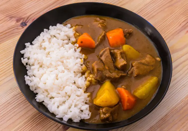 En tallrik med ångande ris och en mustig japansk curry med mört kött, potatis och morötter.