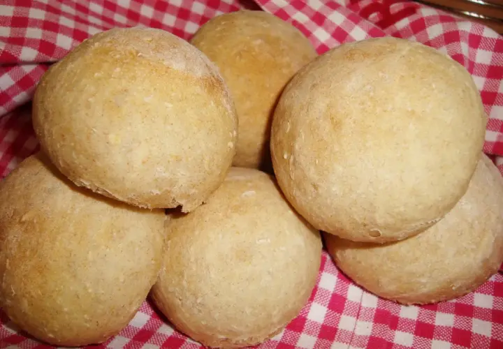 Nybakade bullar på en rödvitrutig duk. Perfekt för ett gott manitoba cream recept.