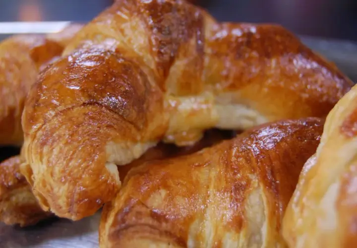 Nybakade, gyllene croissanter som ser ut att vara perfekt att baka.