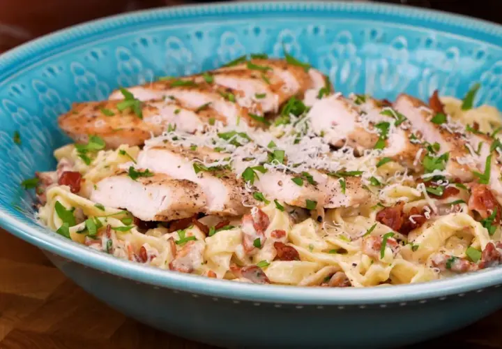 En härlig kyckling pasta med krämig sås, bacon och parmesanost, toppad med färsk persilja.
