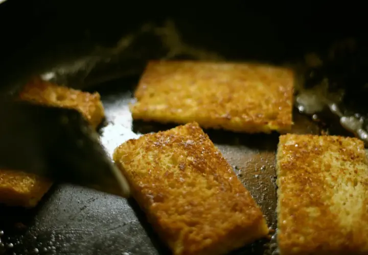 Gyldene skiver av brioche steker i en varm stekepanne. Snart redo att baka brioche!