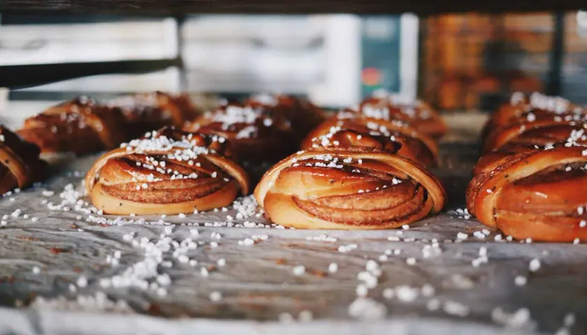 Nybakade kanelbullar, en självklarhet i Sverige, ligger redo att avnjutas. Strösslade med pärlsocker.