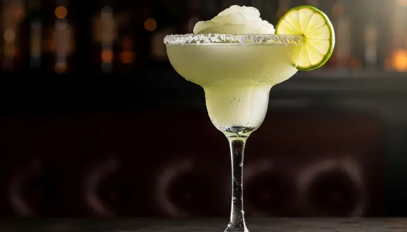 En iskall frozen margarita med saltkant och limeklyfta, perfekt för en varm sommardag.