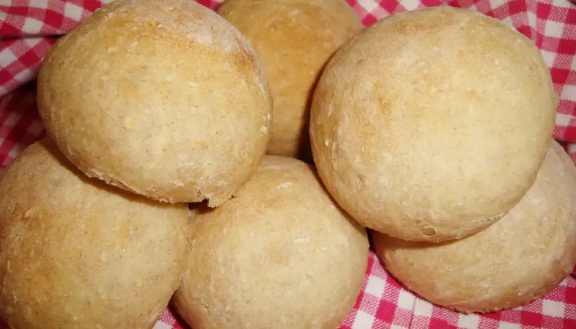 Nybakade bullar på en rödvitrutig duk. Perfekt för ett gott manitoba cream recept.