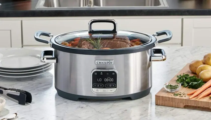 En Crock-Pot slow cooker med en köttbit och grönsaker. Perfekt för ett enkelt slow cooker recept.