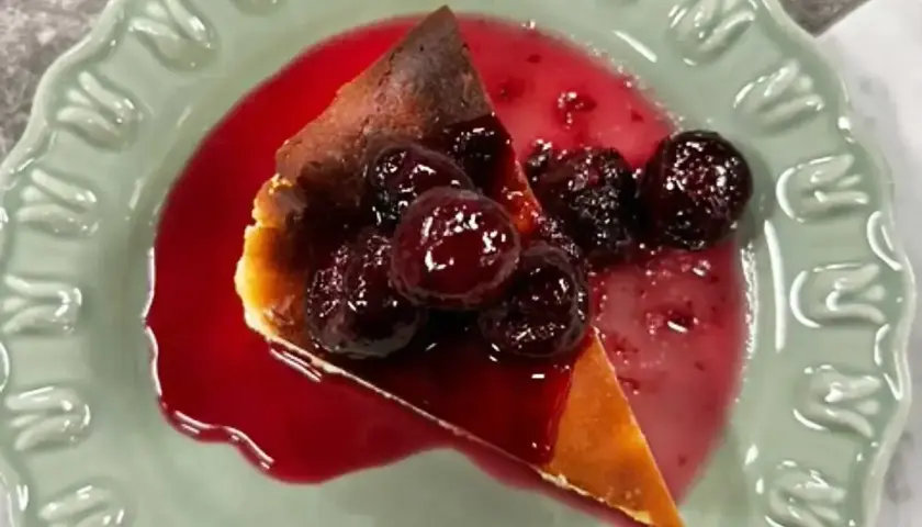 En bit krämig ostkaka med körsbärssås, perfekt för ett ostkaka recept.
