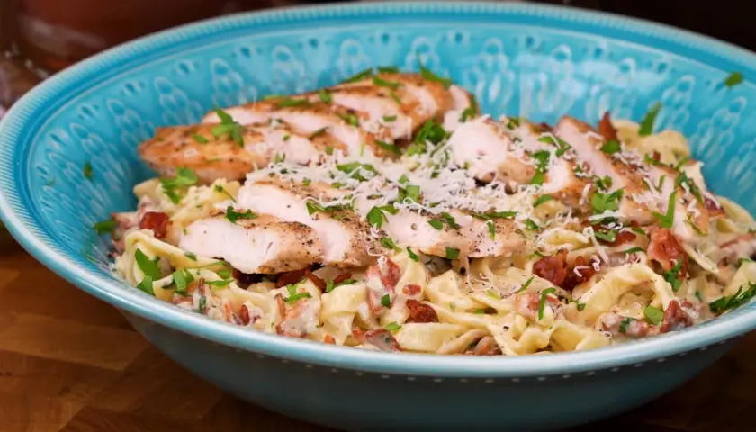 En härlig kyckling pasta med krämig sås, bacon och parmesanost, toppad med färsk persilja.