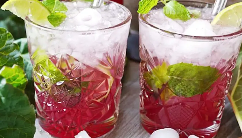 Två glas med rabarber mojito, is, mynta och lime. En uppfriskande sommardrink.