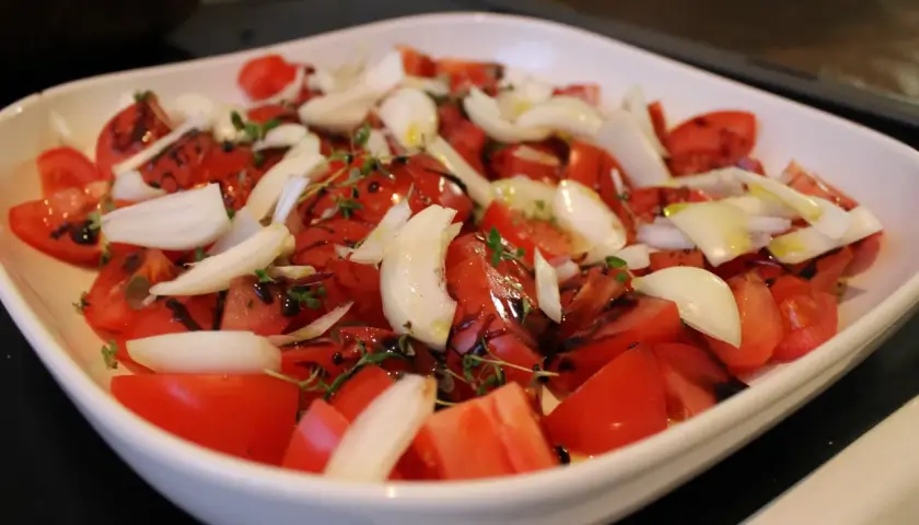 Tomatsallad med lök och örter, redo för ugnen på 200 grader varmluft.