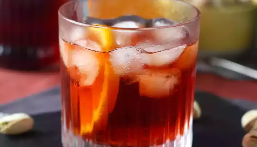 Ett glas Negroni med is och apelsinskiva, perfekt för att följa ett negroni recept.