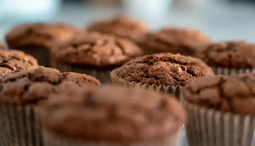 Chokladmuffins i pappersformar. Dessa fluffiga godsaker, som visar vad som innehåller bakpulver, ser aptitliga ut.