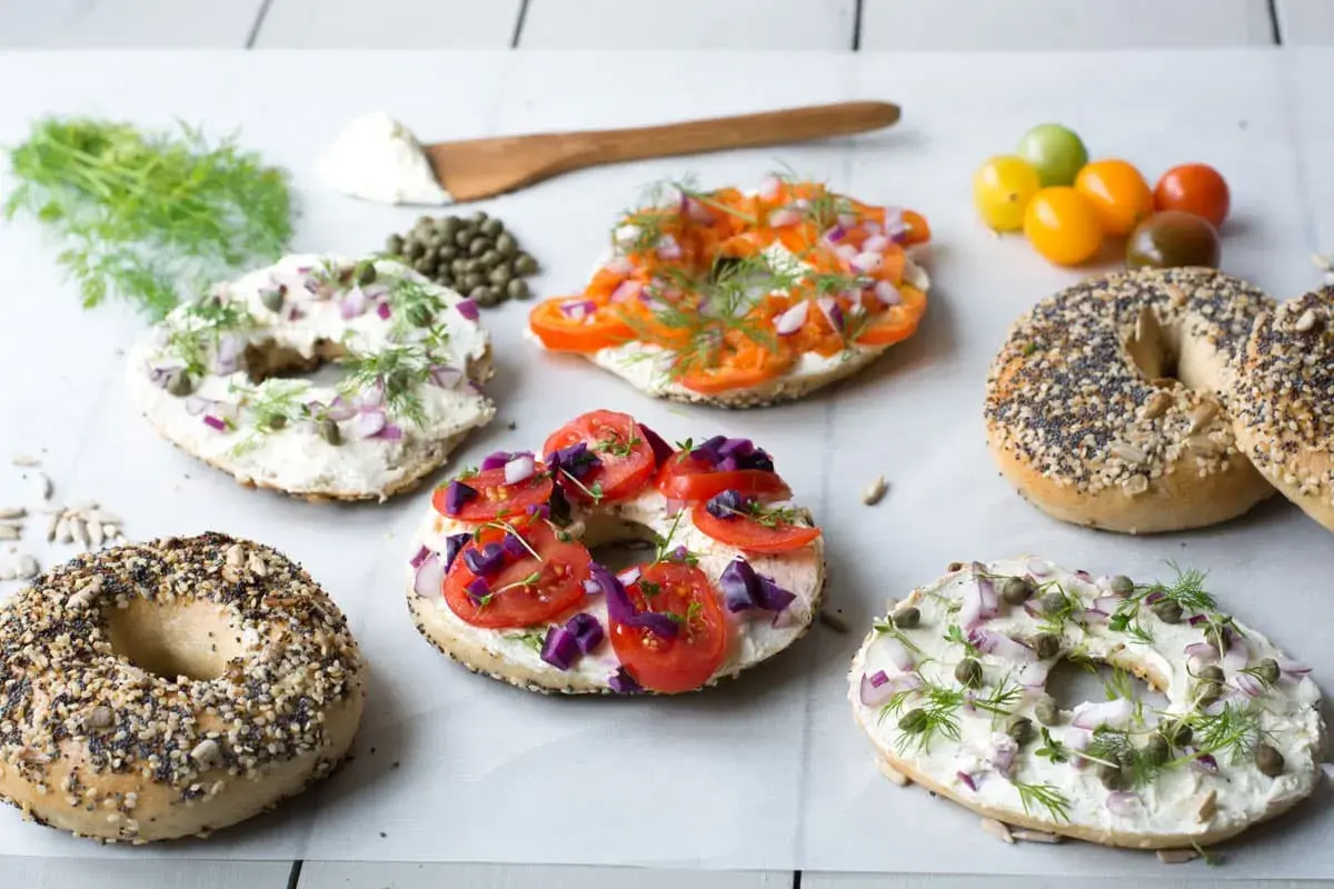 Färgglada bagels med krämig topping, tomat, lök och dill. Ett härligt bagels recept för frukost eller brunch.