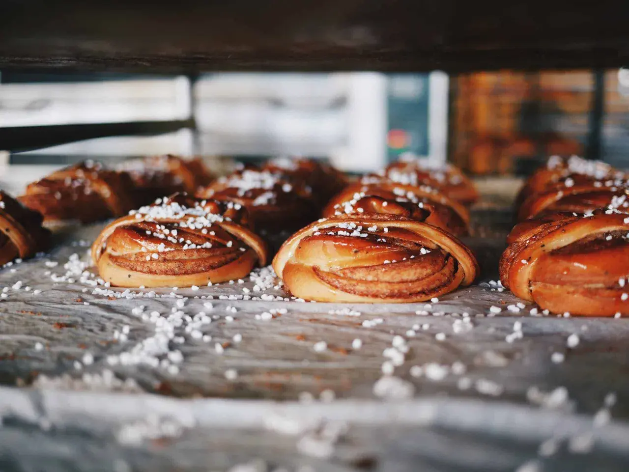 Nybakade kanelbullar, en självklarhet i Sverige, ligger redo att avnjutas. Strösslade med pärlsocker.