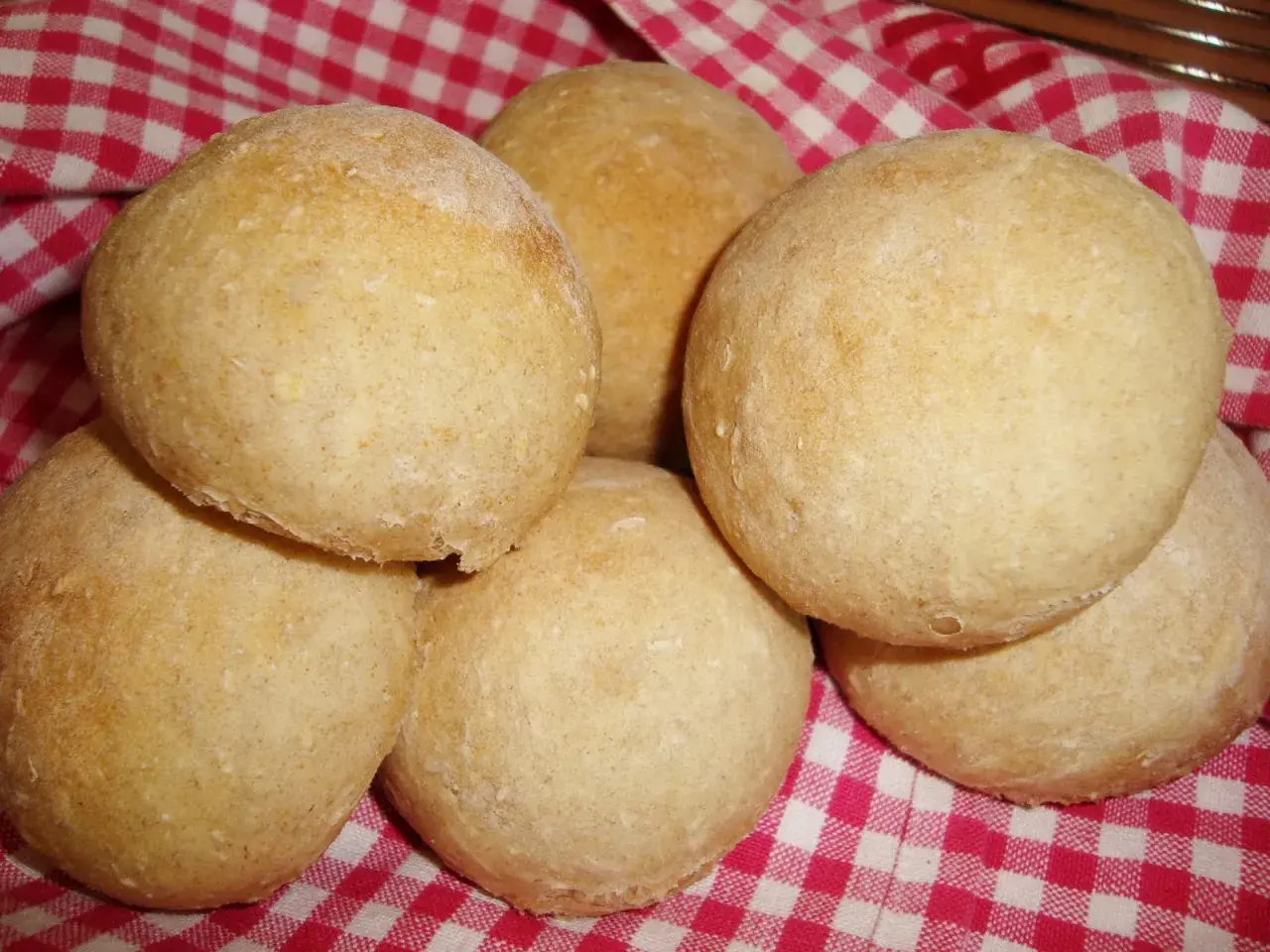 Nybakade bullar på en rödvitrutig duk. Perfekt för ett gott manitoba cream recept.