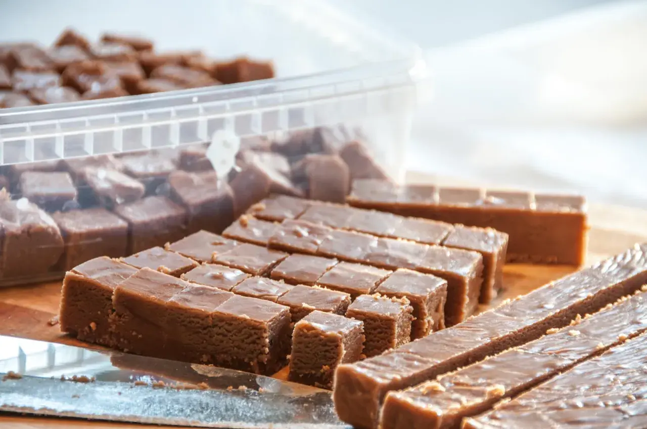 Fudge i en burk och uppskuren på ett bräde. Perfekt för ett enkelt fudge recept choklad.