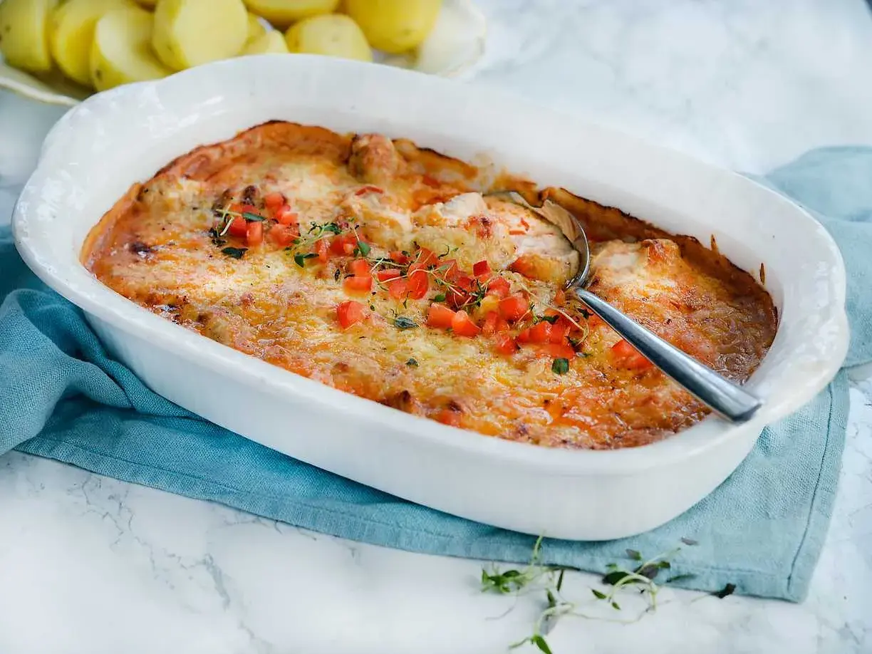 Gratinerad kycklinglårfile i ugnsform, toppad med tomat och örter. Ett härligt kycklinglårfile recept för middagen.