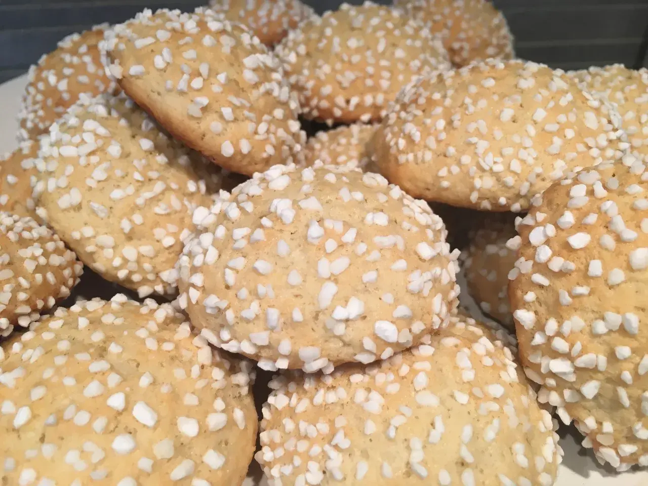 En hög med gyllene mandelkubbar, perfekta för ett enkelt mandelkubb recept. De är toppade med pärlsocker för extra krispighet.