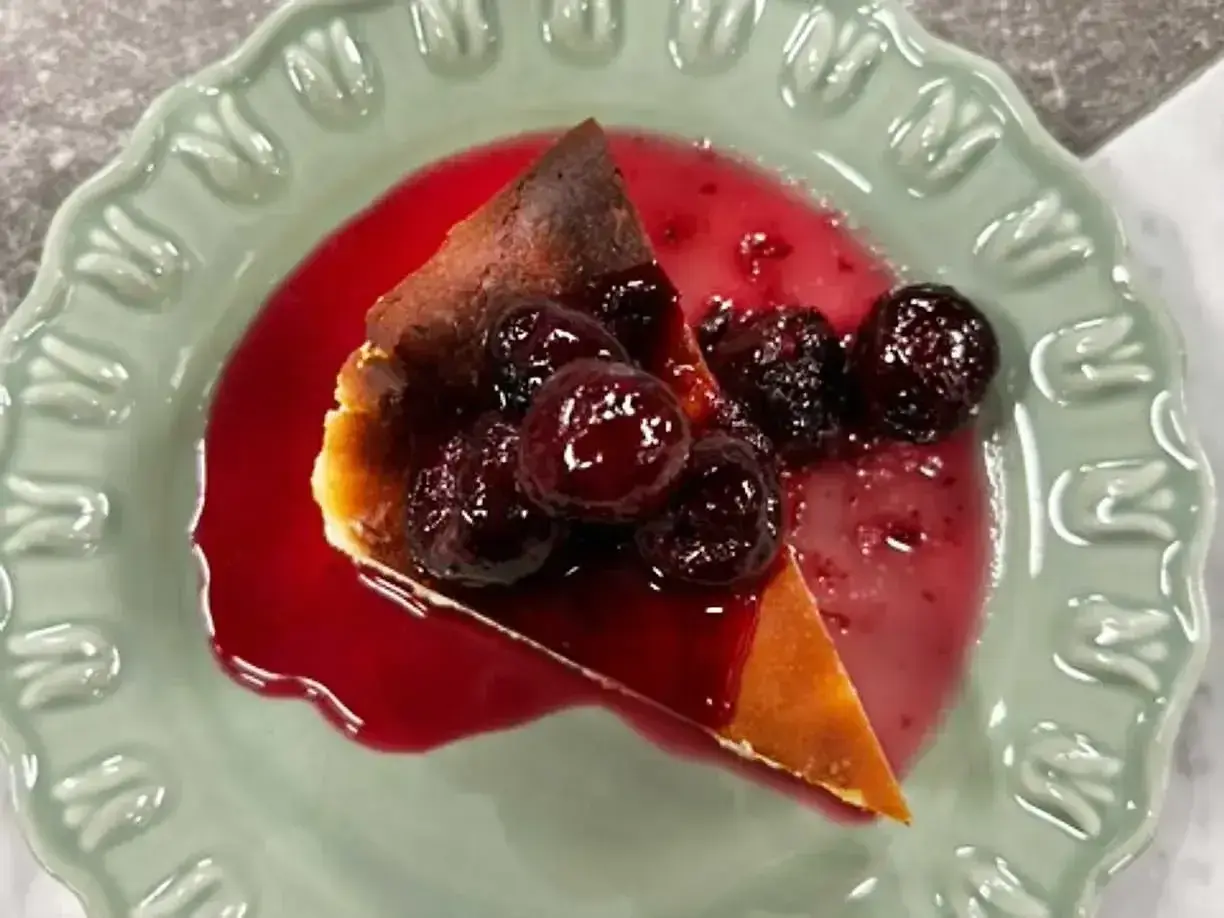 En bit krämig ostkaka med körsbärssås, perfekt för ett ostkaka recept.