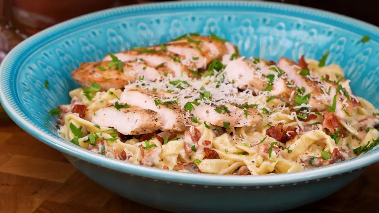 En härlig kyckling pasta med krämig sås, bacon och parmesanost, toppad med färsk persilja.