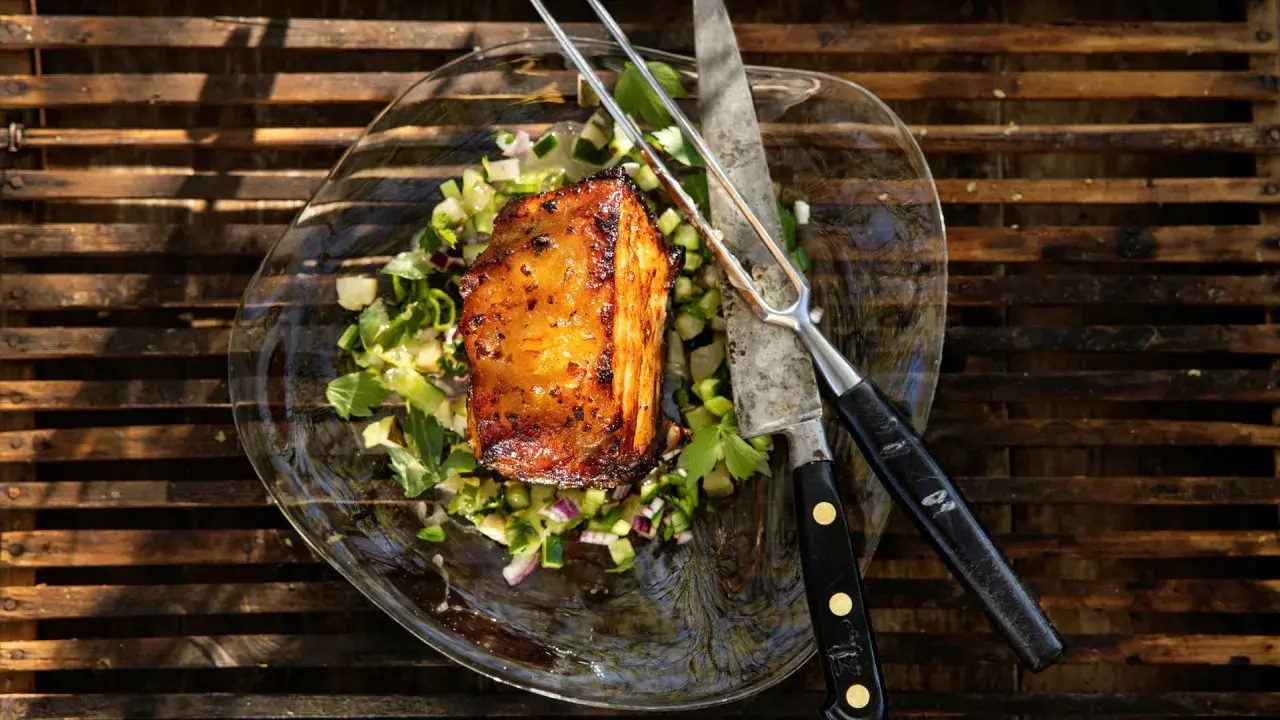 En saftig köttbit med grönsallad, kniv och gaffel. Perfekt för ett libbsticka recept.