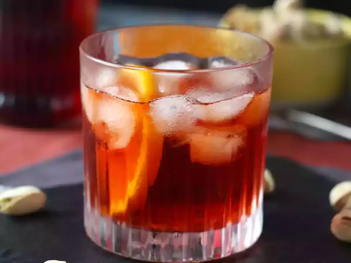 Ett glas Negroni med is och apelsinskiva, perfekt för att följa ett negroni recept.
