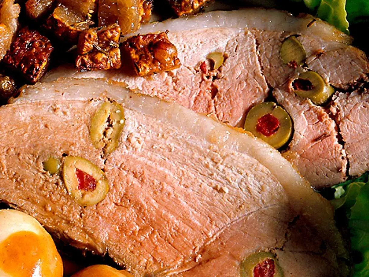 Skinkstek recept: saftig skinkstek fylld med oliver och serverad med potatis och en krispig sallad.
