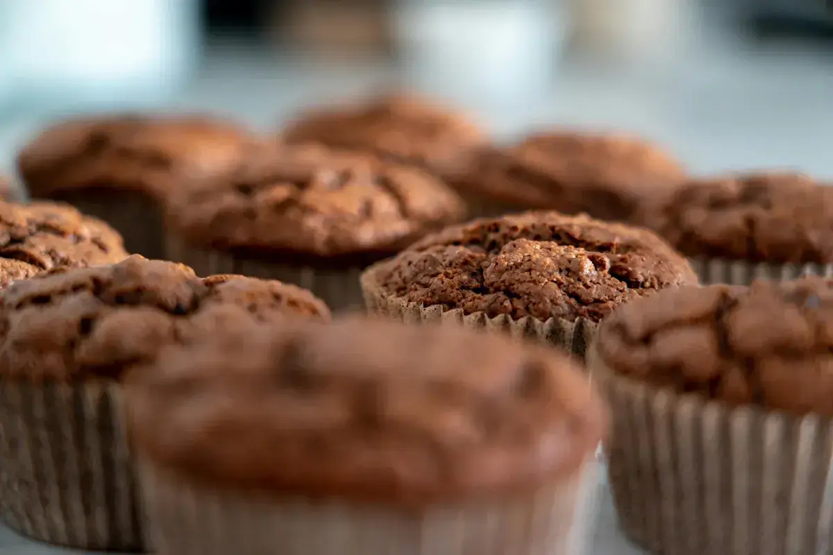 Chokladmuffins i pappersformar. Dessa fluffiga godsaker, som visar vad som innehåller bakpulver, ser aptitliga ut.
