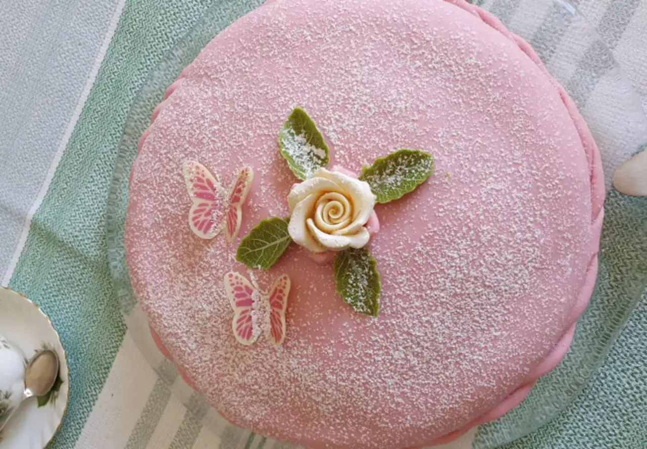 En rosa prinsesst&aring;rta med marsipanros, blad och fj&auml;rilar. En vacker t&aring;rta som skiljer sig fr&aring;n en operat&aring;rta.