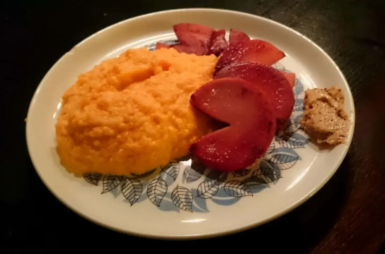 En tallrik med krämigt rotmos utan potatis, röda äppelklyftor och en klick senap. En härlig måltid!