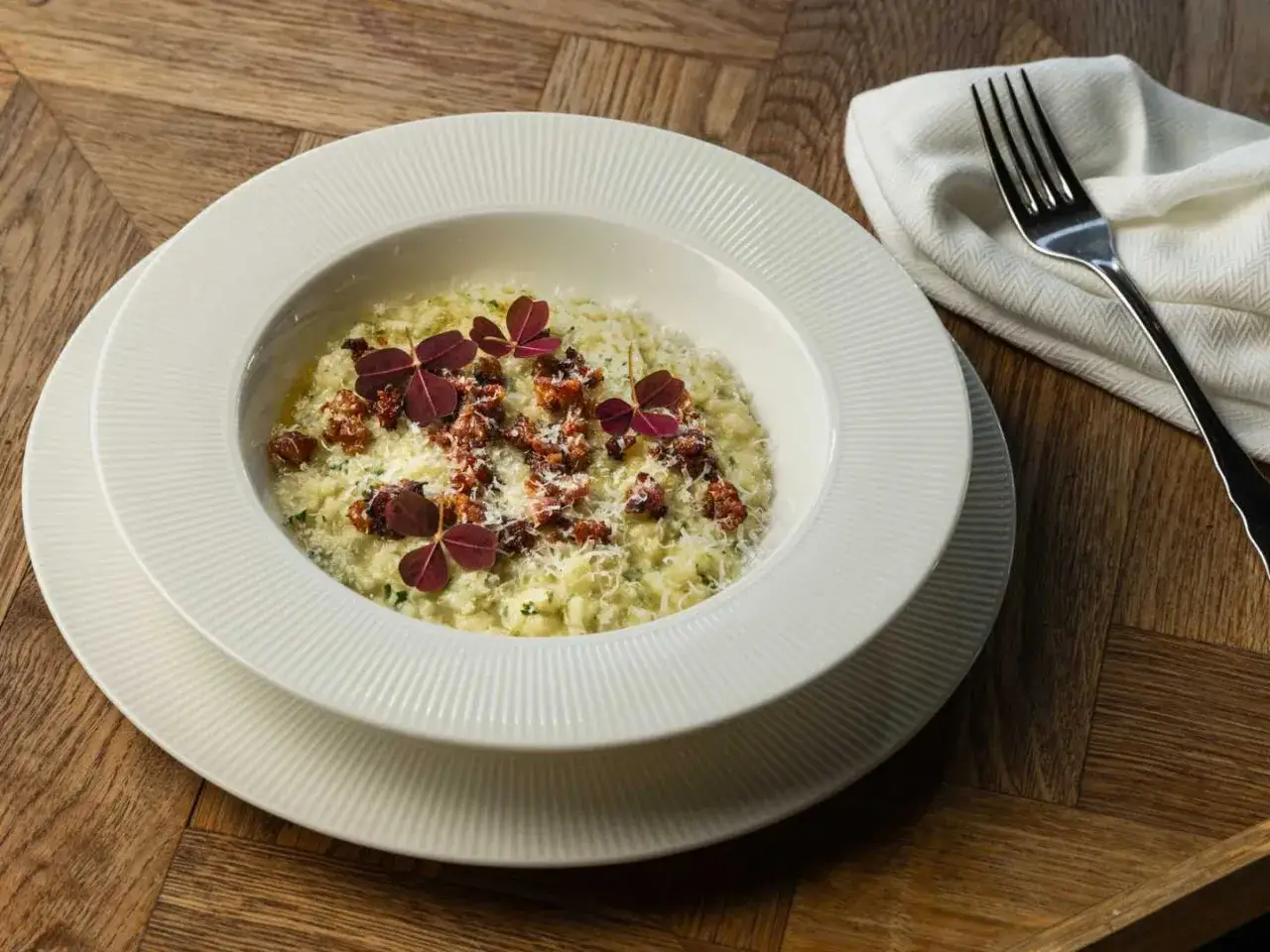 Kr&auml;mig risotto med toppning av smulad korv och r&ouml;da kl&ouml;verblad. Ett perfekt risotto recept f&ouml;r en lyxig middag.