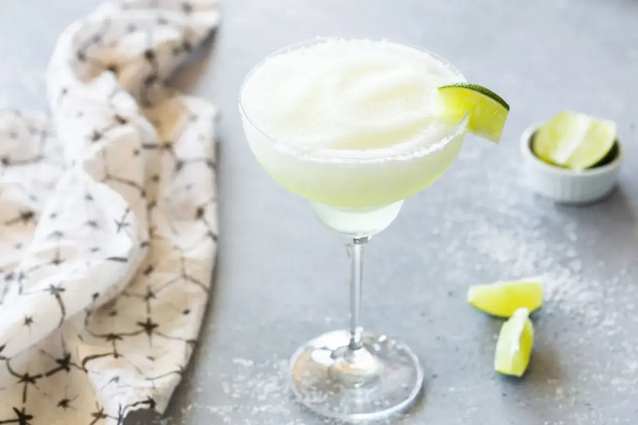 En frostig frozen margarita med limeklyfta och saltkant. Perfekt för en varm sommardag.