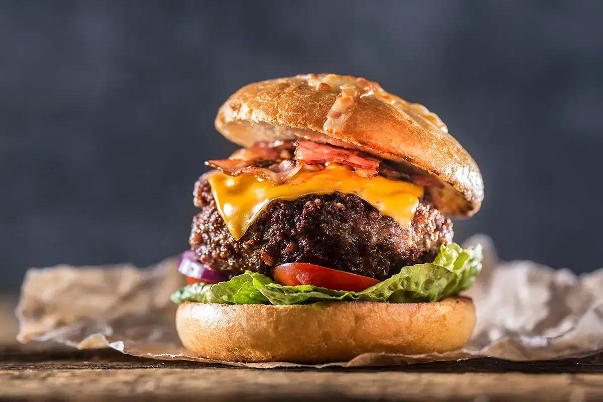 En saftig hamburgare med ost och bacon, perfekt f&ouml;r att grilla hamburgare en solig dag.