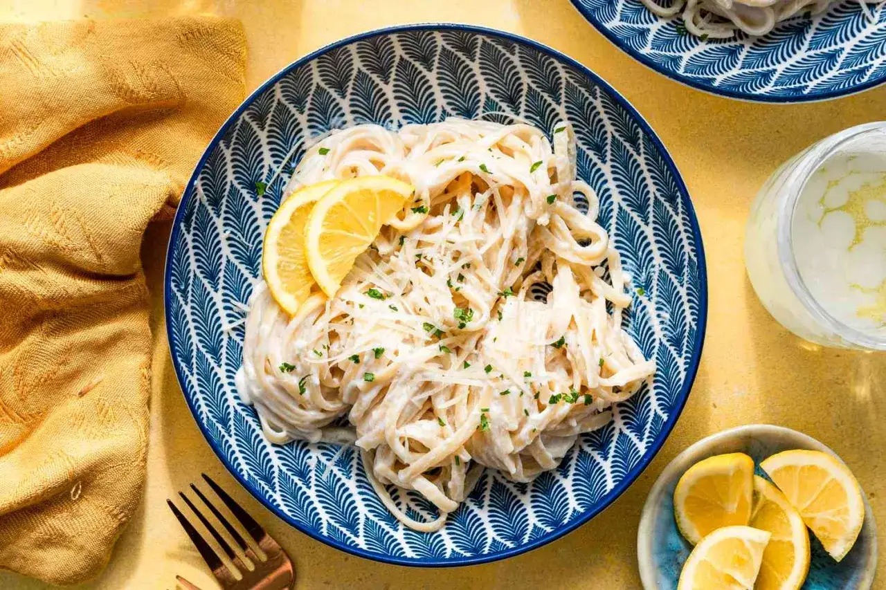 En tallrik kr&auml;mig pasta limone med citronskivor och f&auml;rska &ouml;rter. Enkel och god vardagsmat.