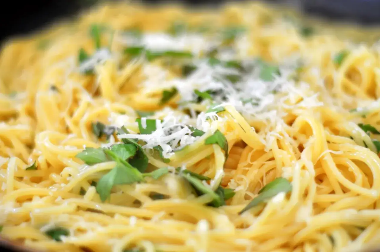 En n&auml;rbild p&aring; en tallrik spaghetti med f&auml;rska &ouml;rter och riven ost. Perfekt f&ouml;r ett snabbt libbsticka recept.
