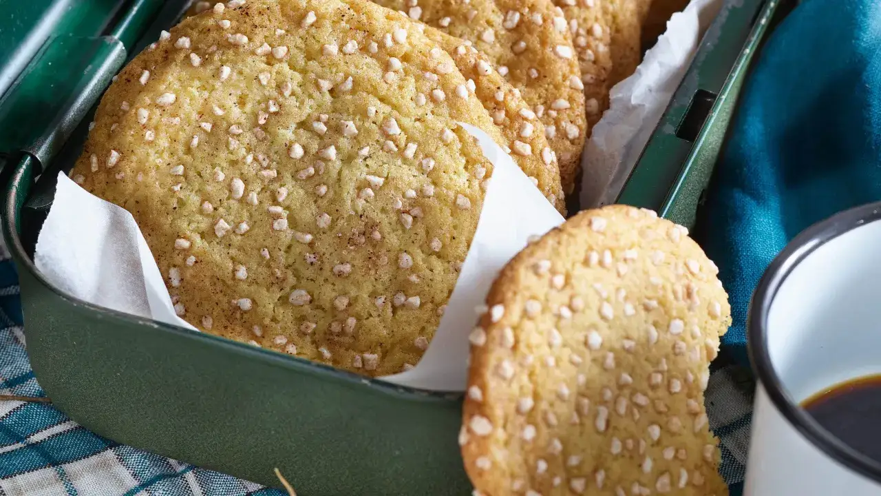 Krispiga snickerdoodle-kakor med pärlsocker i en grön plåtburk. Perfekt för ett mysigt fika.