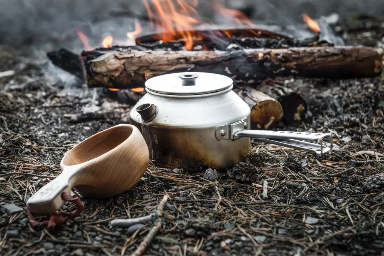 Koka kaffe p&aring; gammalt vis vid l&auml;gerelden. En k&aring;sa och en kaffepanna v&auml;ntar p&aring; att fyllas med v&auml;rmande dryck.