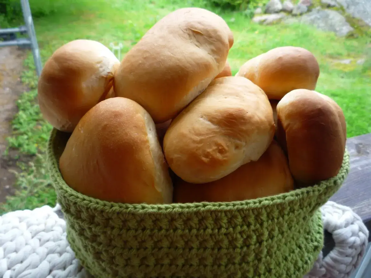 Nybakade bullar i en gr&ouml;n virkad korg, perfekta f&ouml;r ett Manitoba cream recept.