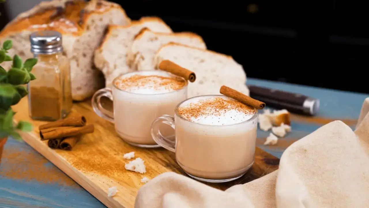 Tv&aring; koppar kr&auml;mig chai latte med kanelst&auml;nger och str&ouml;dd kanel. Perfekt f&ouml;r ett mysigt chai latte recept.